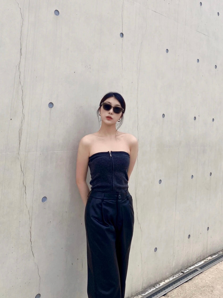 Mesmerizing in her black dress, this woman stands tall and proud by the wall, radiating an aura of luxury and refinement wearing her Korean fashionable sunglasses.