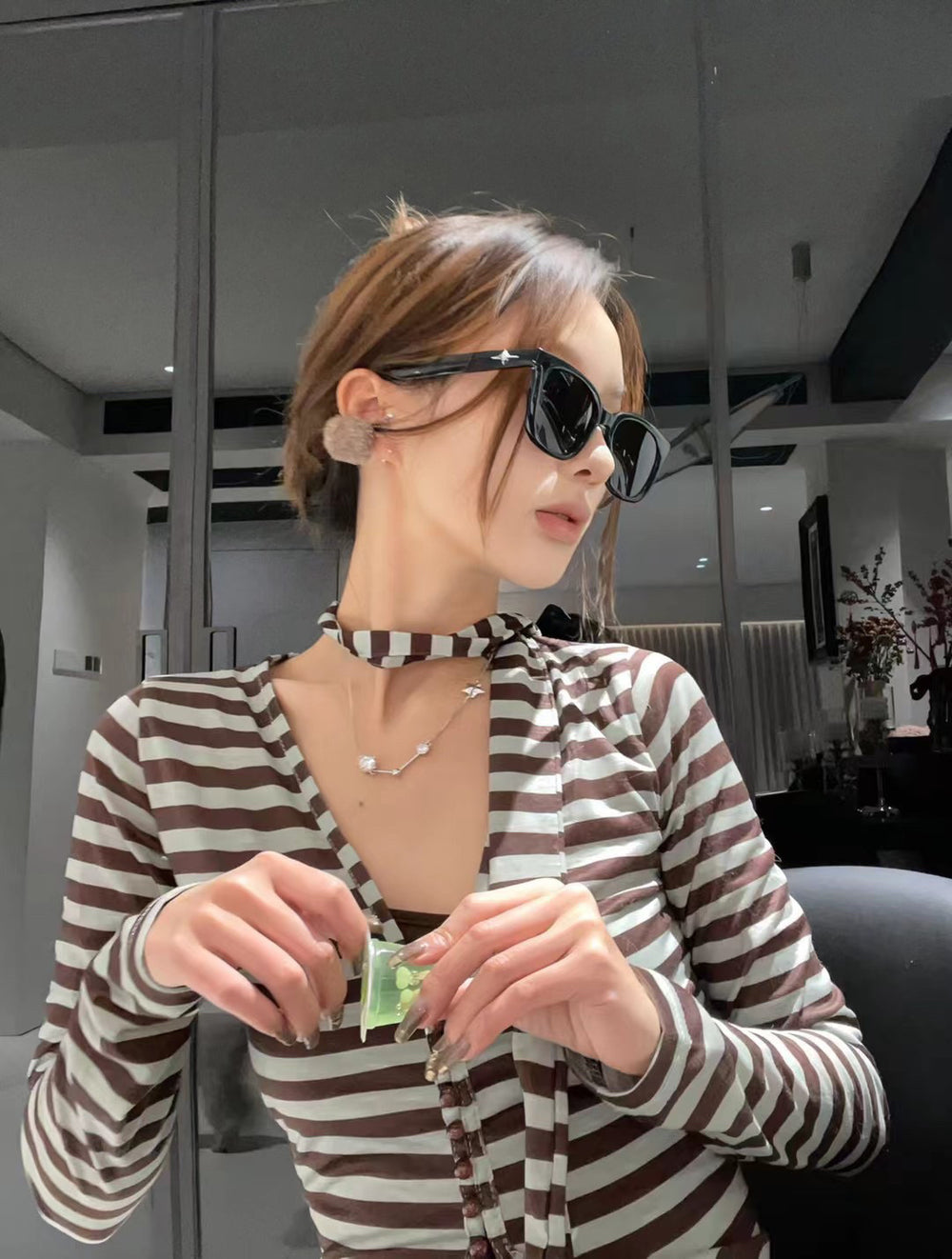 With her striped shirt and fashionable sunglasses, this woman exudes an aura of sophistication and impeccable style.