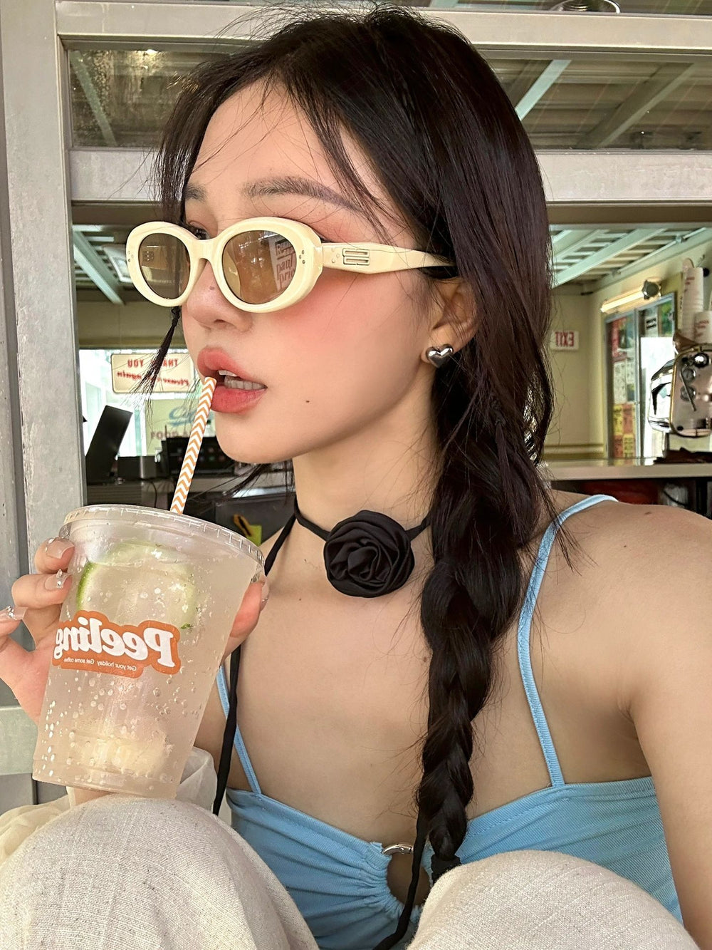 An elegant woman, adorned with fashionable sunglasses, gracefully cradling a tantalizing drink, epitomizing luxury and leisure.