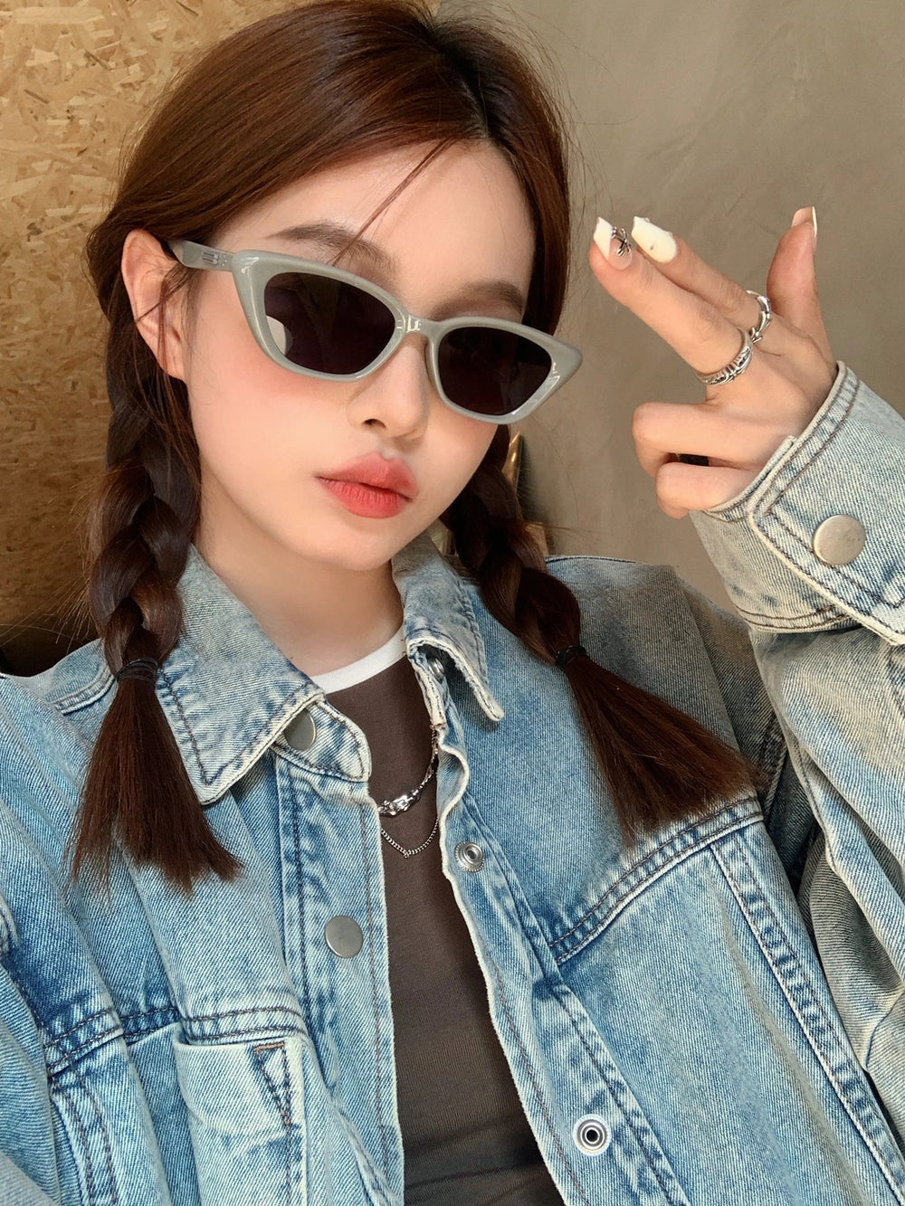 With a denim jacket that epitomizes casual luxury, the woman exudes confidence and style, her sunglasses adding a hint of intrigue to her captivating allure.