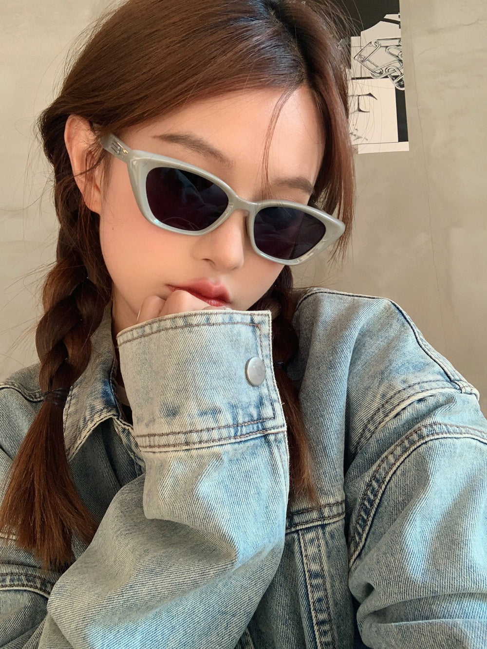 An effortlessly cool woman dons sunglasses and a denim jacket, epitomizing casual yet fashionable style.