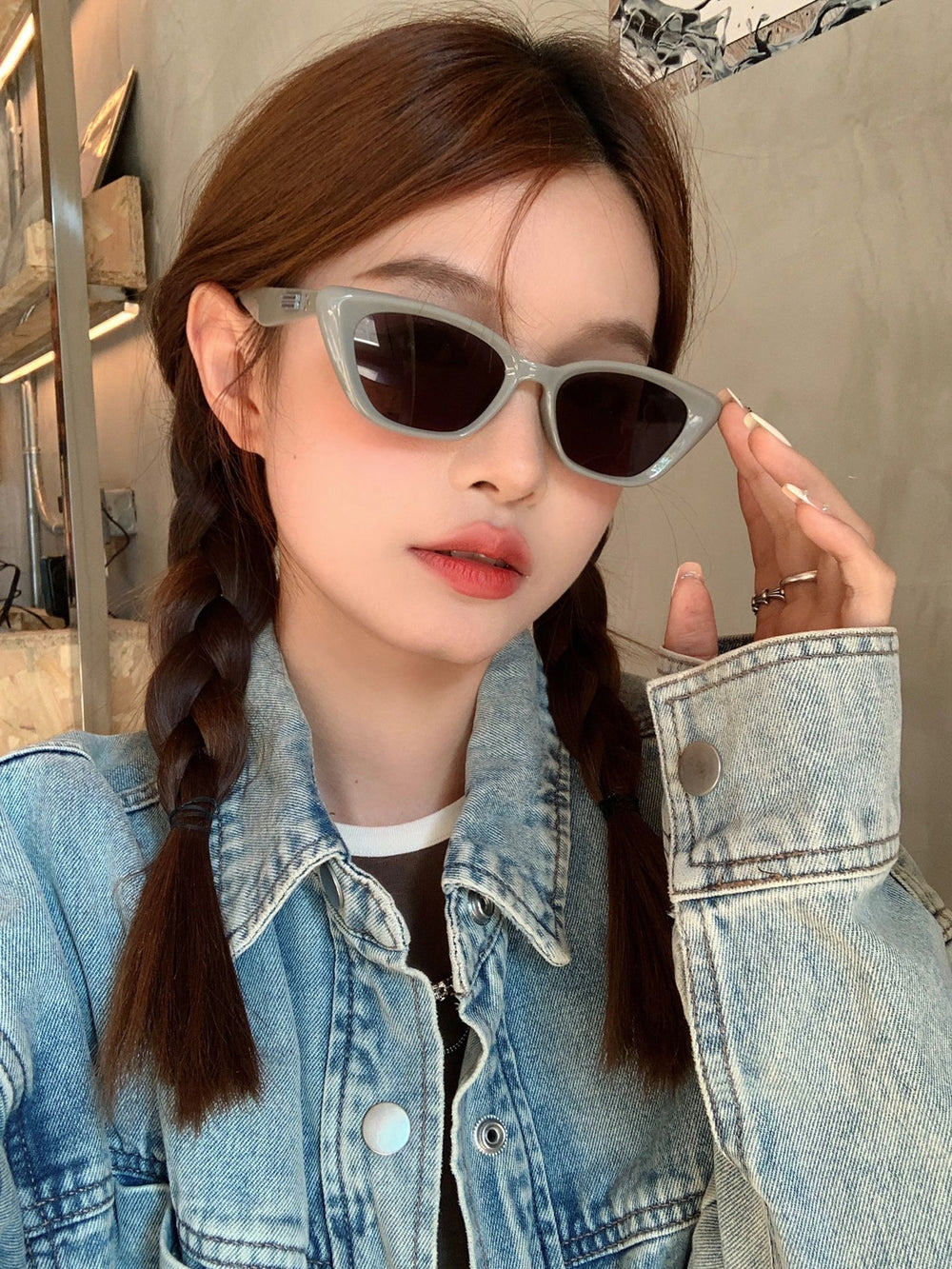 Trendy woman rocks sunglasses and a denim jacket, adding a touch of chic to her ensemble.