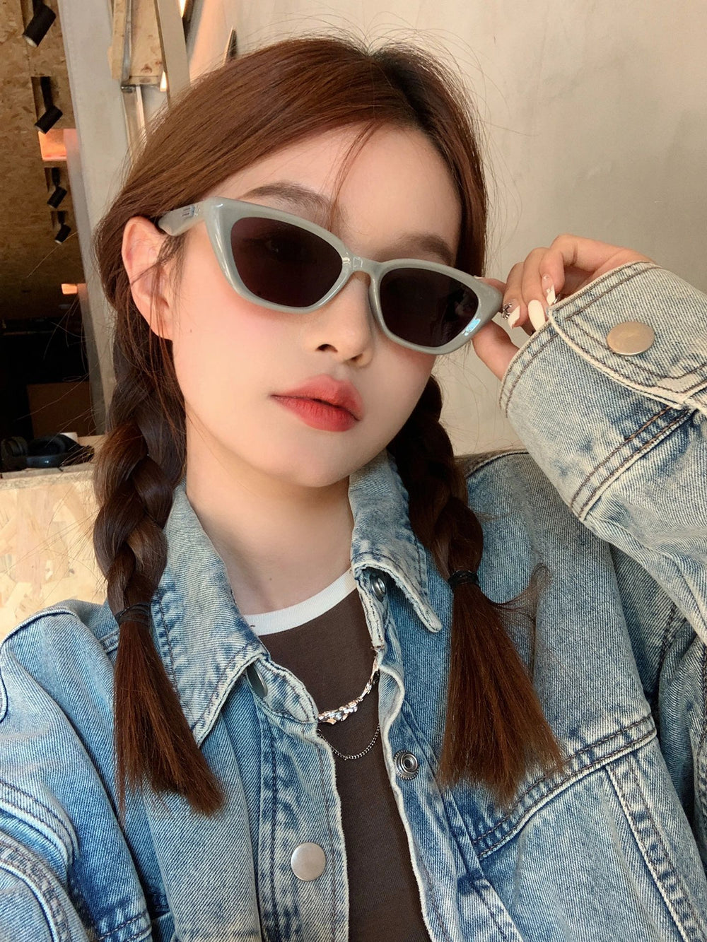 Fashionable lady dons sunglasses and a denim jacket, showcasing her effortless style.