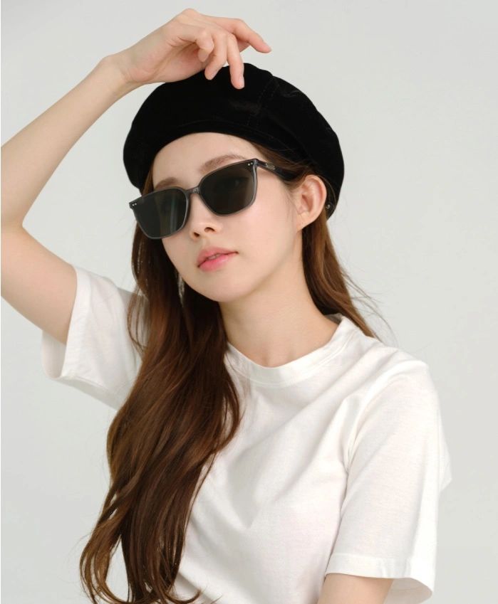 A fashion-forward lady, accentuating her ensemble with a stylish hat and trendy sunglasses, radiating sophistication.
