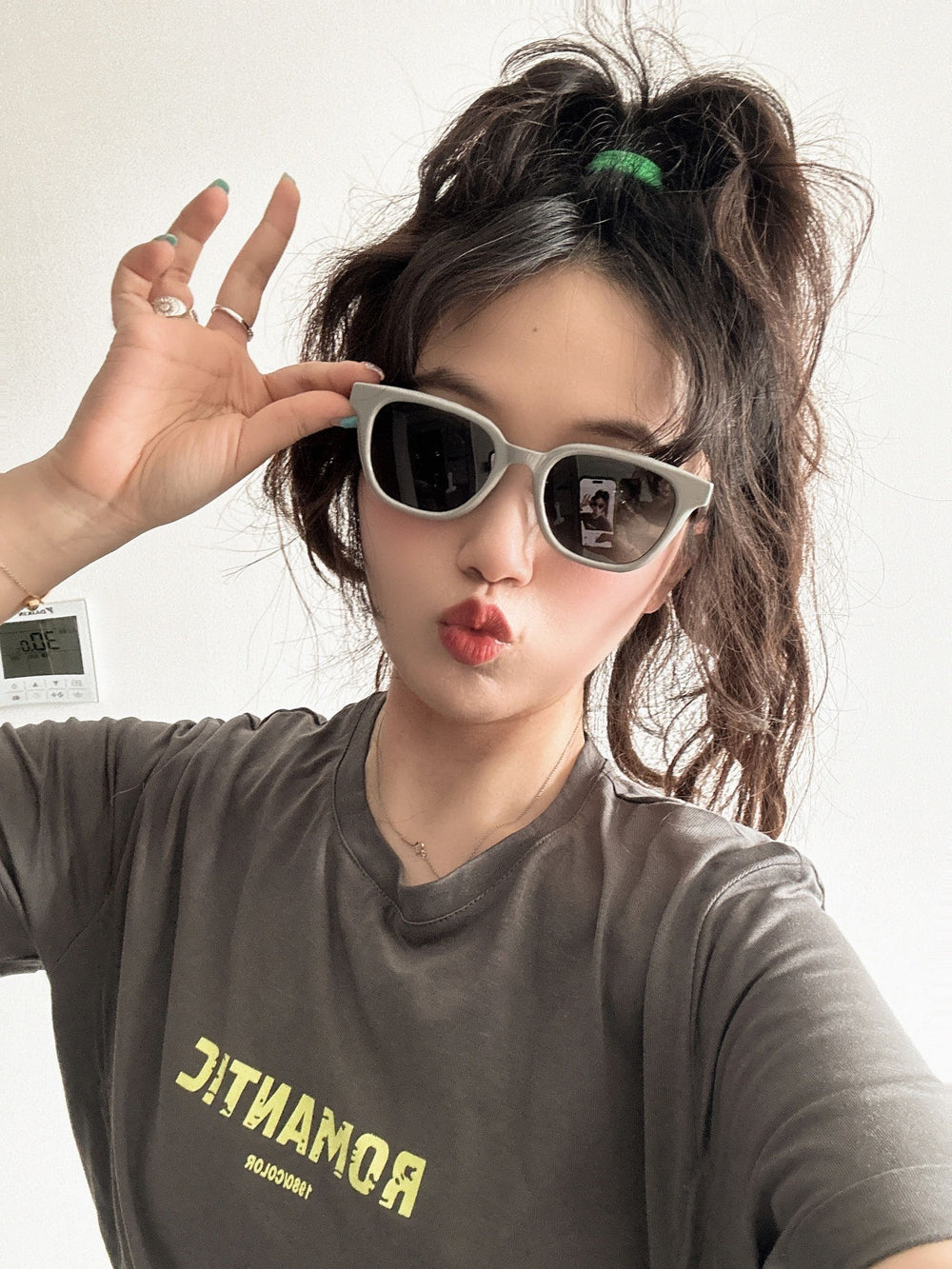 With her Korean  fashion sunglasses and t-shirt, the woman showcases a laid-back yet trendy style.