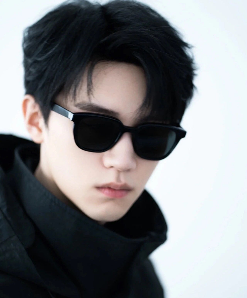 A trendy guy rocks sunglasses and a black jacket, adding a touch of mystery to his look.
