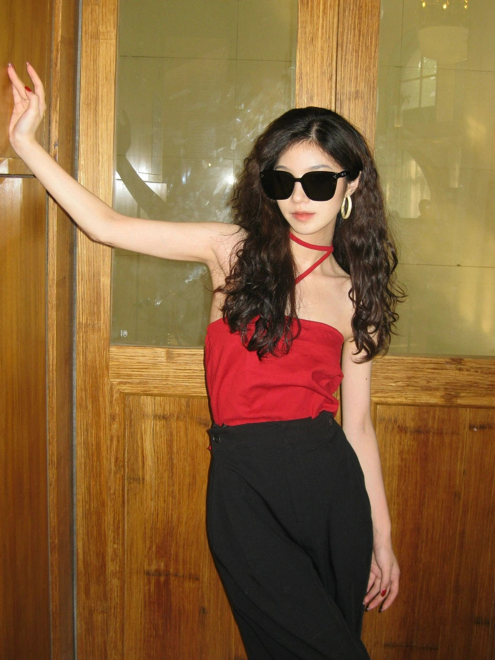A captivating lady adorned in a striking red top and a fashionable black skirt, radiating confidence and allure wearing her Korean fashionable sunglasses.