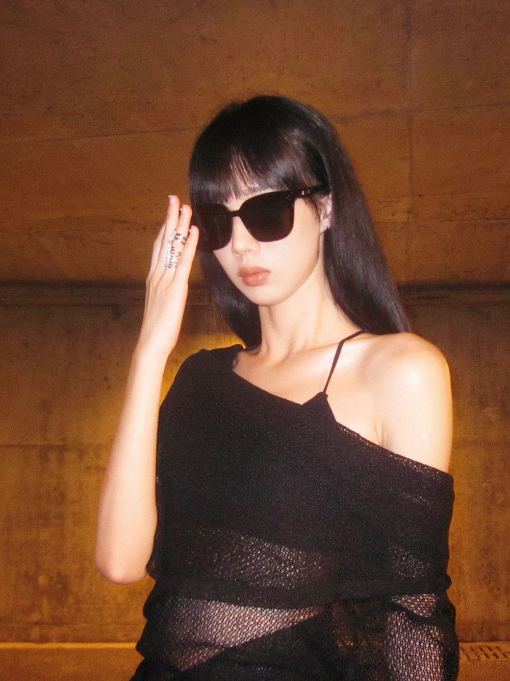 A captivating woman exudes elegance in her sleek black dress, complemented by stylish sunglasses. She exudes an air of mystery and sophistication. 