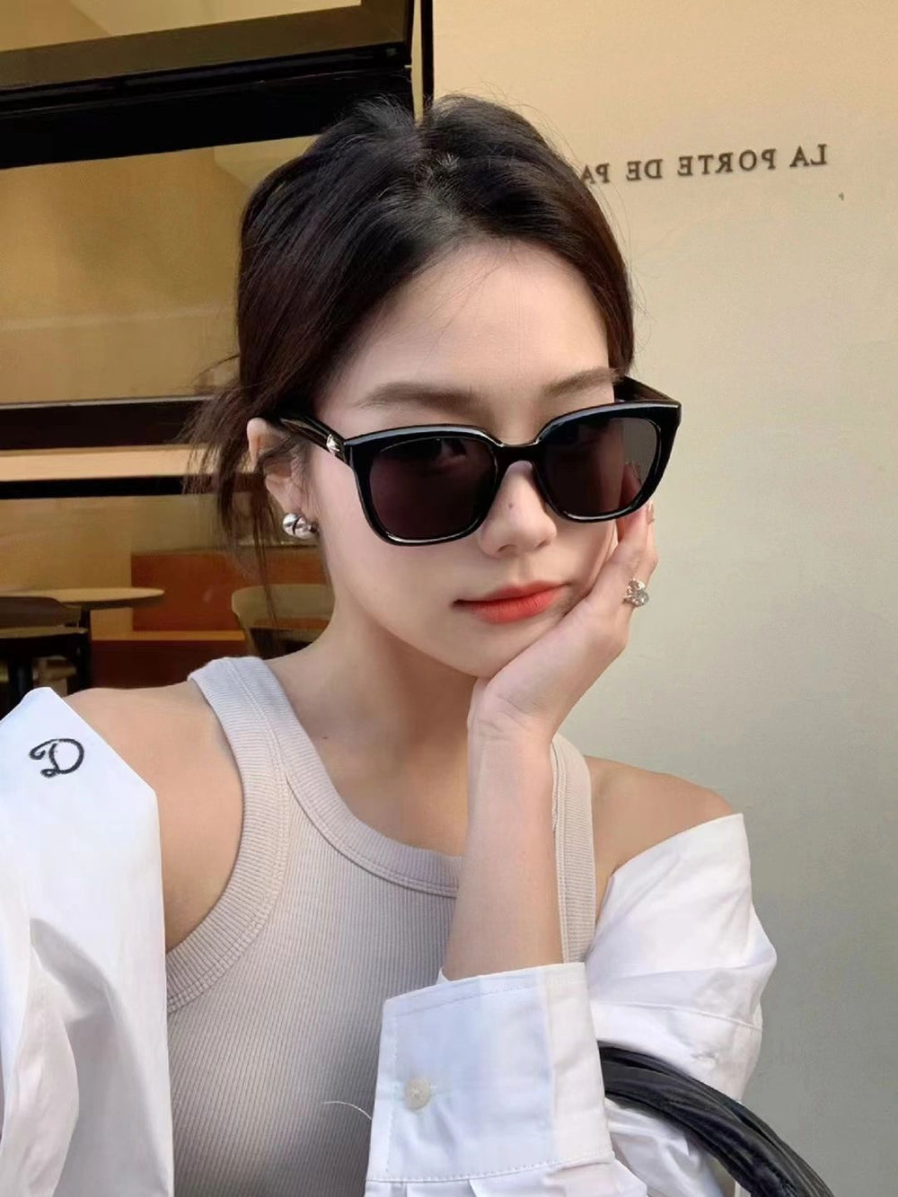 A fashionable lady sporting Korean stylish sunglasses and a pristine white shirt exudes timeless grace.