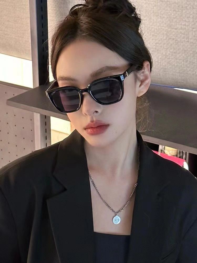 With an air of effortless style, a woman exudes confidence in her black blazer and fashionable sunglasses, embodying the essence of elegance.