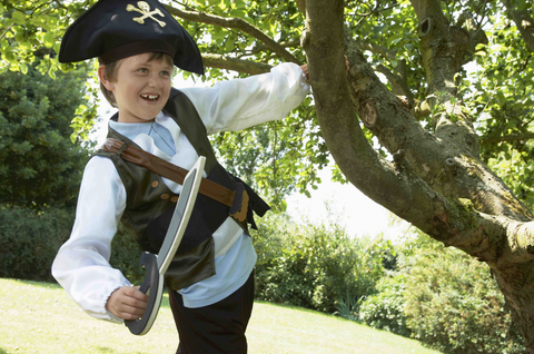 child hanging out of a tree dressed as a pirate