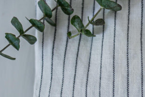 nachhaltige Mode in Form einer weißen Leinenbluse in Nahaufnahme mit Eukalyptuszweig