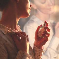 Woman spraying herself with fragrance