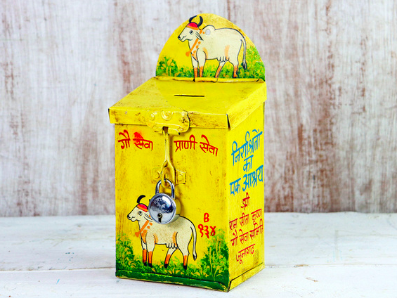 Vintage yellow money box featuring Indian writing and Cow illustrations