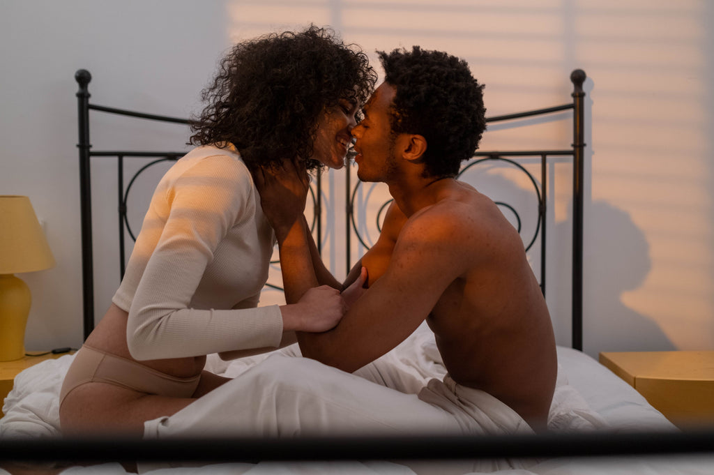 African American Couple Kissing in Bed Naked