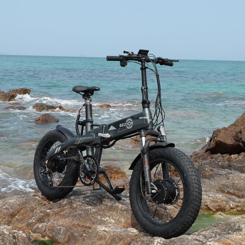 Bezior XF005 opvouwbare   elektrische fiets gepositioneerd op rotsachtige kustlijn, ideaal voor stedelijke ontdekkingsreizen