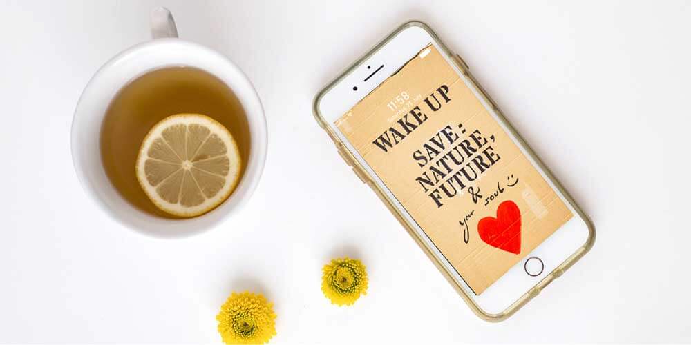 Table flatlay with motivational wallpaper on a phone