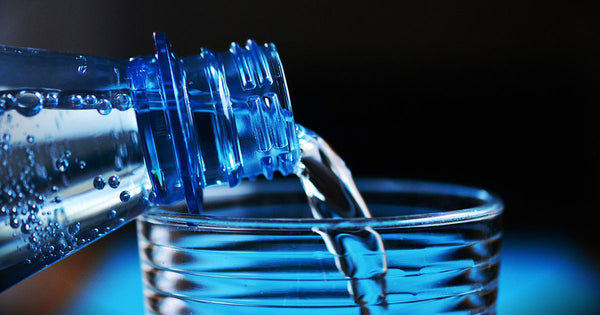 A bottle of mineral water being poured in a glass