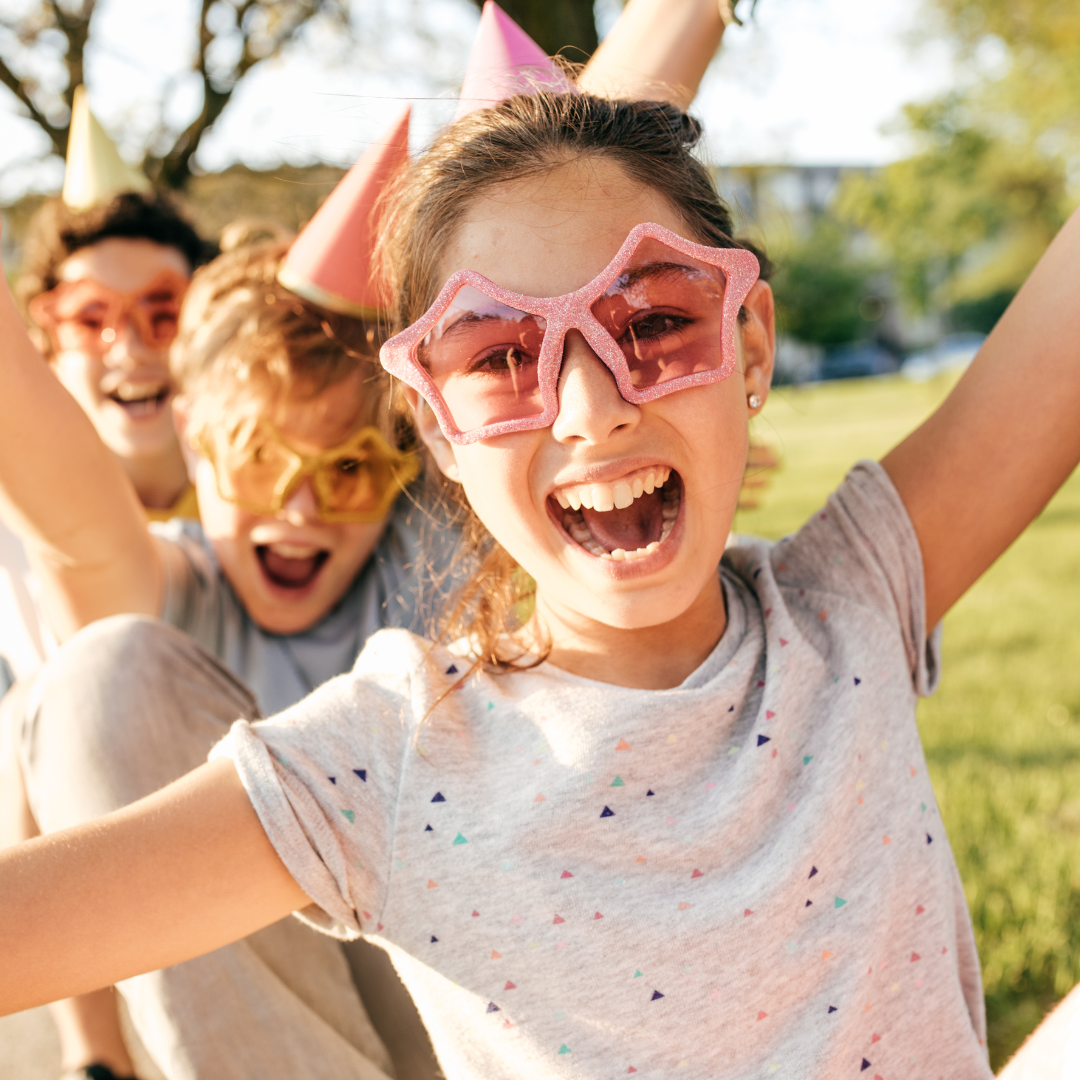 Children smiling and wearing star-shaped glasses.