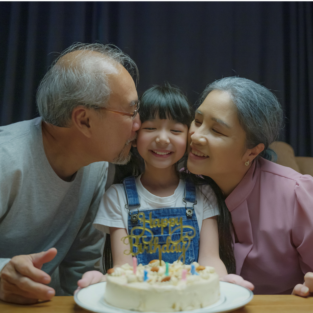Grandparents kissing their granddaughter on her birthday.