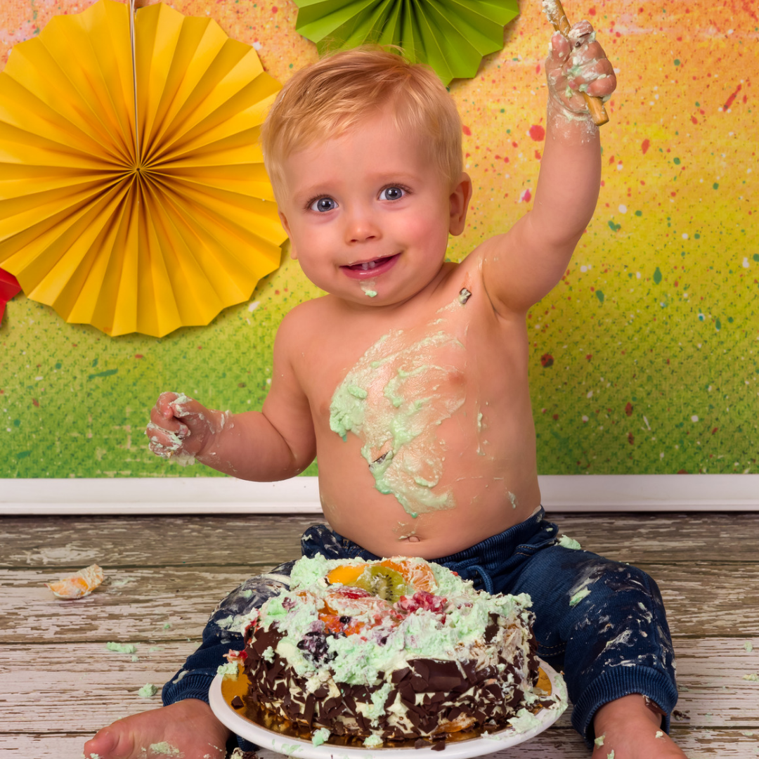 A toddler eating his birthday cake.