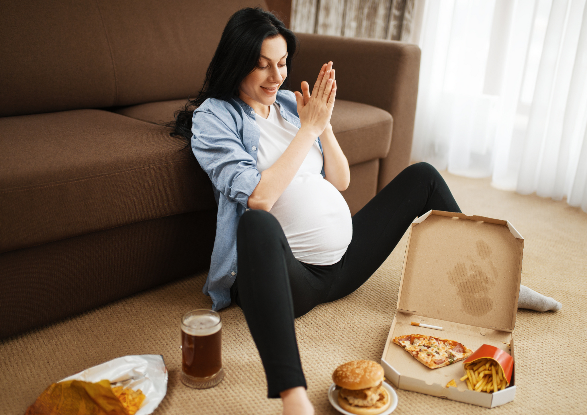 A pregnant lady looking at junk food.