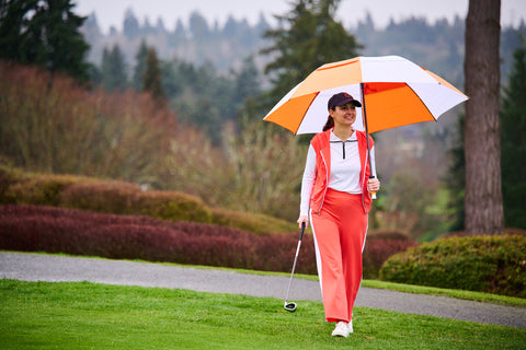 Woman on the golf course under an umbrella