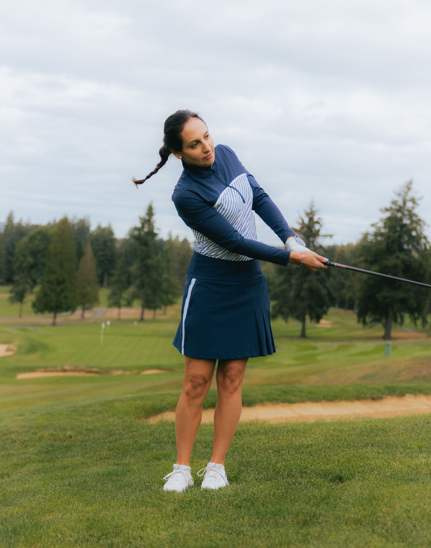 A woman swinging a club on a golf course