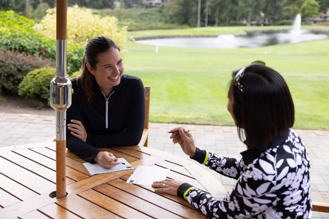 Two women sitting at a wooden table