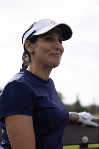 A woman wearing a dark blue golf shirt