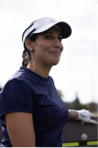 A woman wearing a white visor and a blue shirt