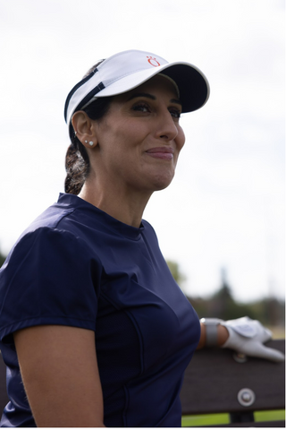 A woman wearing a dark blue golf shirt