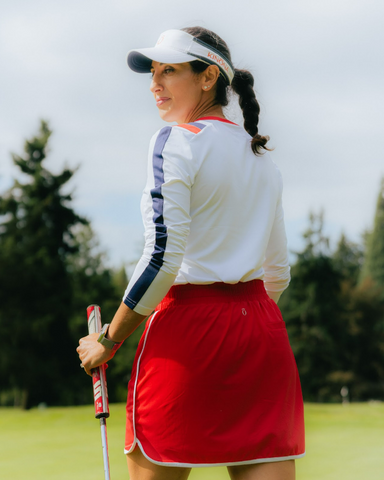 A woman wearing a white long-sleeved shirt and red skirt