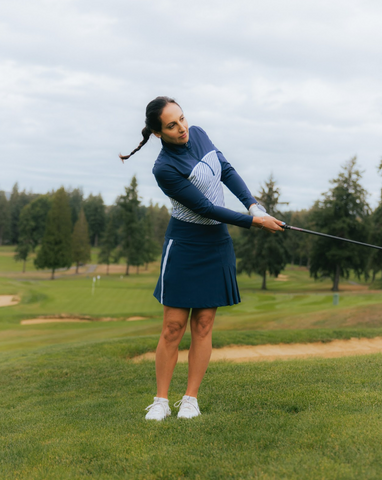 A woman practicing her swing on the golf course