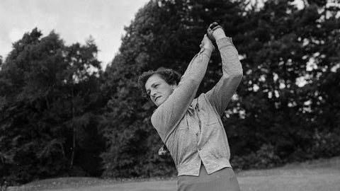 Babe Zaharias swinging a golf club in black and white.