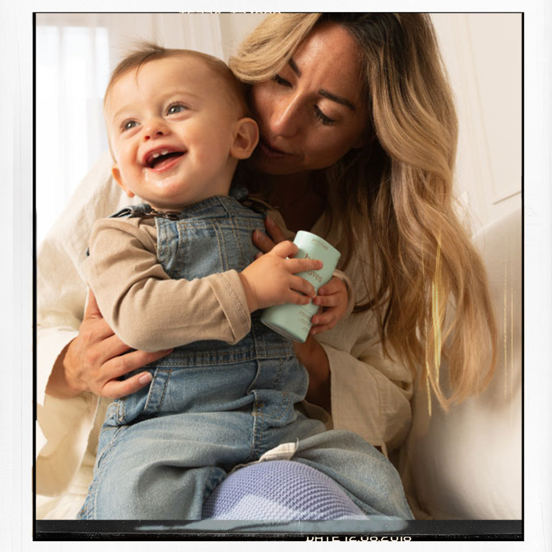 mum and baby holding a balm bottle