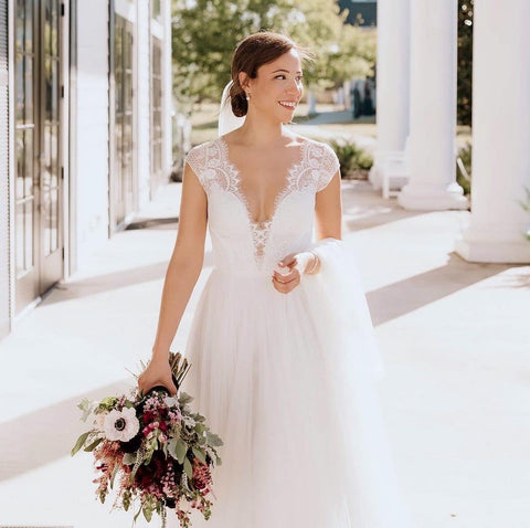 Lace cap sleeves wedding dress on a bride with her hair back in the sun