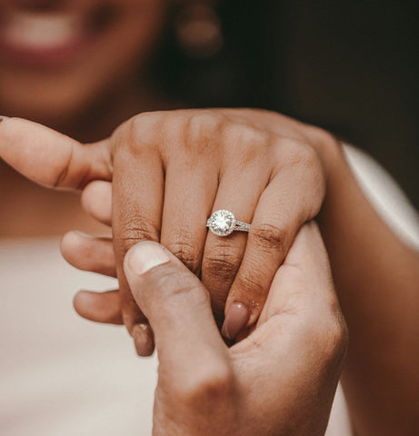 Newly engaged beautiful smiling Black woman beaming with love showing her gorgeous wedding ring.