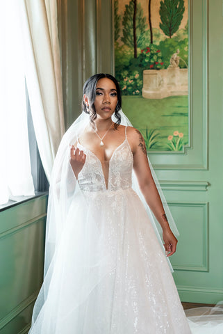 A beautiful a-line tulle wedding gown with sequins on a beautiful woman by Margo West