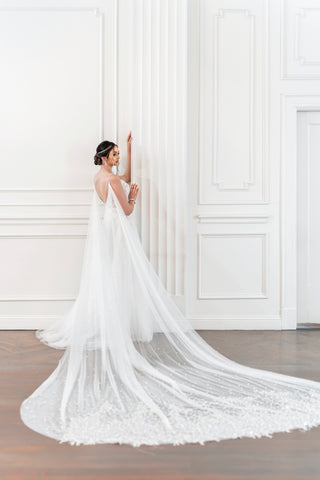 Gorgeous detachable cape on a white stunning wedding dress