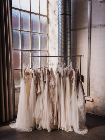 Wedding dress shopping beautiful wedding gowns on a rack.