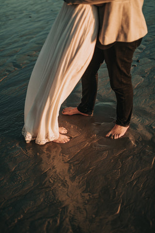 Wedding on the beach with bride and groom barefoot in the sandy water