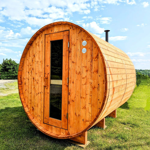 spruce barrel sauna with wood fired stove and wood door on grass stained sauna