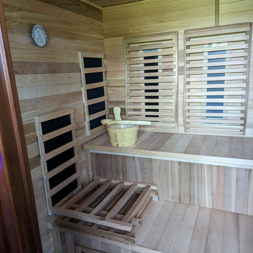 Interior of cedar infrared sauna benches with sauna bucket and ladel