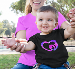 Dog Infant Clothing. A mother holding her baby boy's hand. Baby is wearing a dog t-shirt with  a heart and colorful pink and purple dog paw.