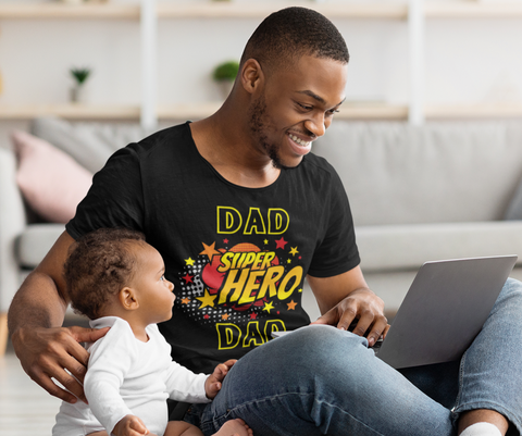 Family, Dad Clothing, T-shirts, Gifts. Baby sitting next to his dad wearing a black t-shirt with an emblem stating  Dad Superhero.