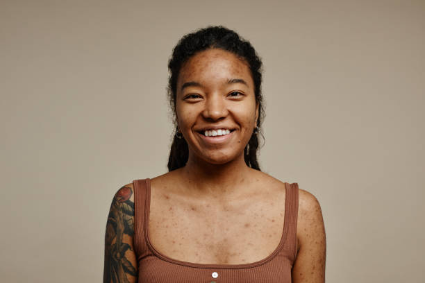 Smiling woman with tattoos on her arm.