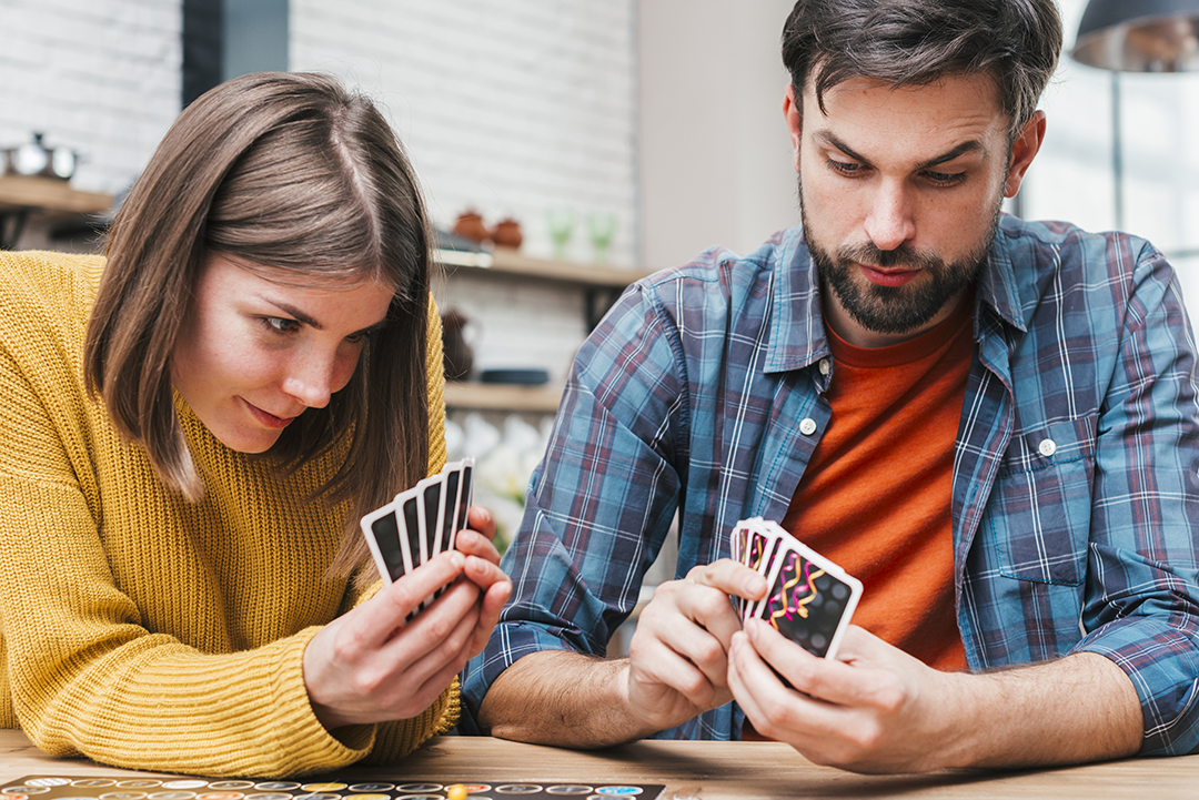 Glückliches Paar spielt Brettspiele zu zweit zu Hause - gemeinsame Aktivitäten, Beziehungsbau, Strategie- und Partnerspiele.