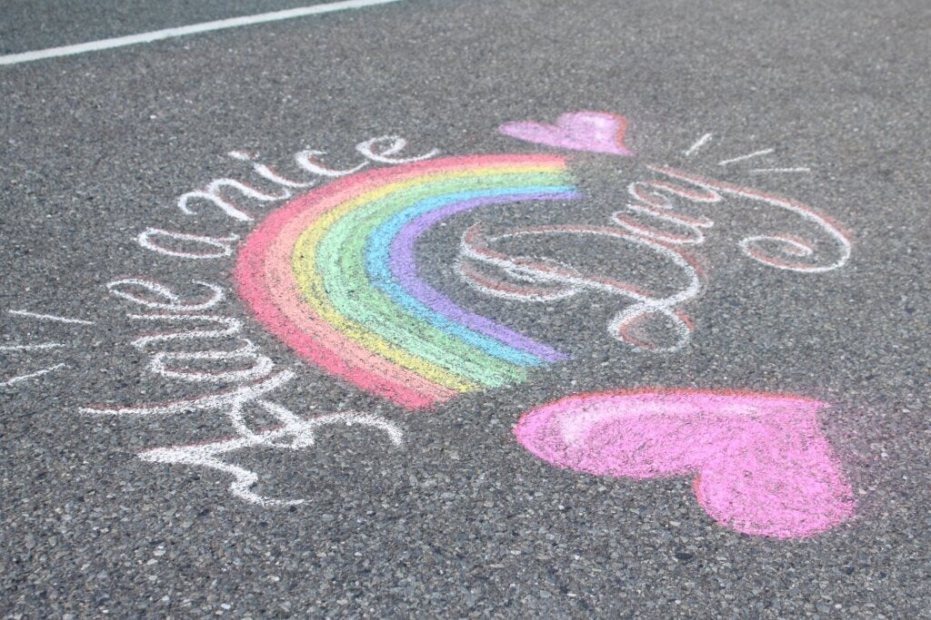 Pavement art using vibrant Kitpas chalks showing a rainbow, hearts and 'Have a nice day' quote. 