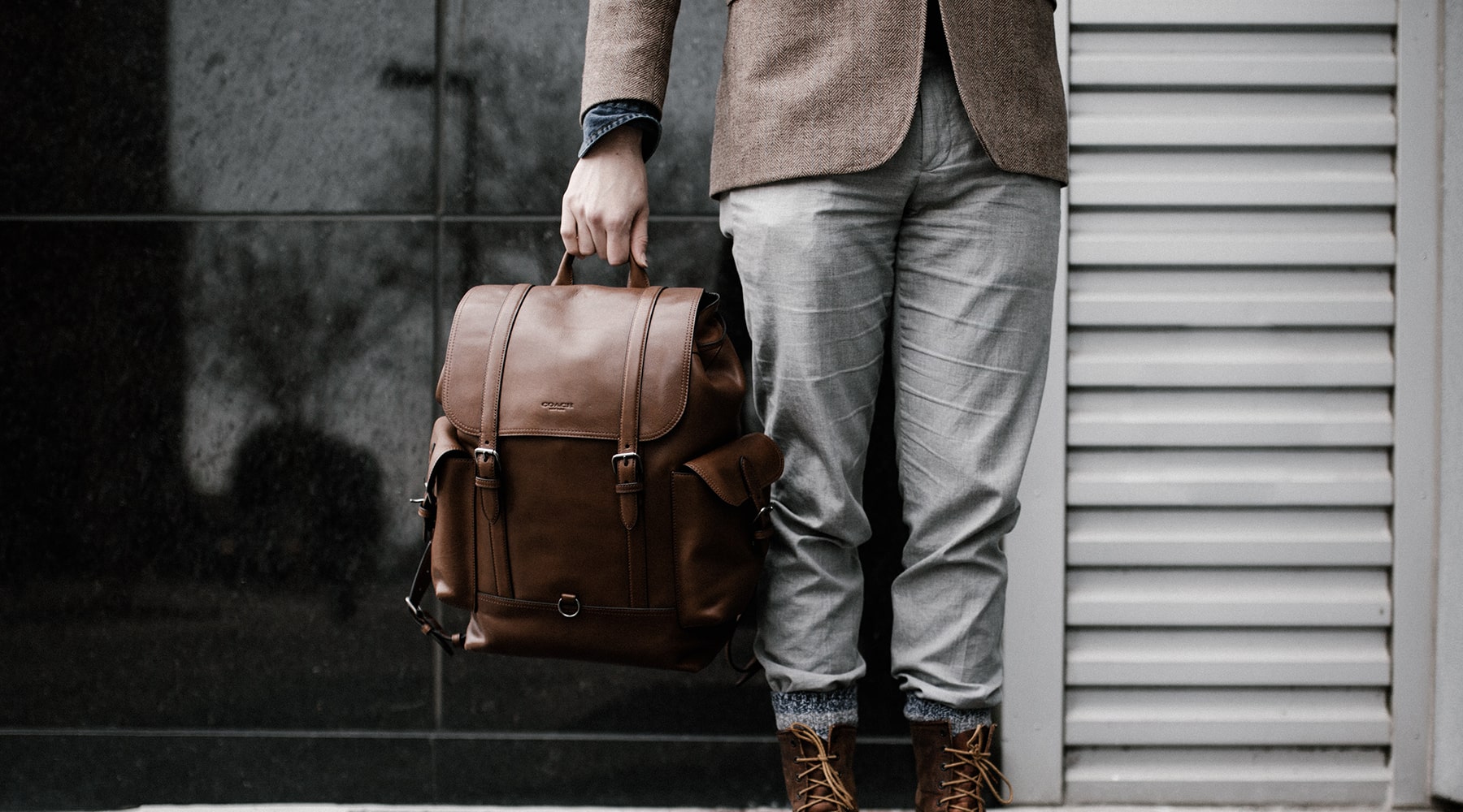 man-holding-leather-backpack